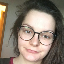 [Translate to English:] Foto von Friederike Köller. Frau mit langen braunen Haaren lächelt in die Kamera.