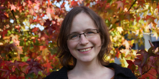 Astrid Slojewski (Verwaltungsangestellte) Porträt von Frau Astrid Slojewski. Frau mit braunen schulterlangen Haaren und Brille lächelt in die Kamera.