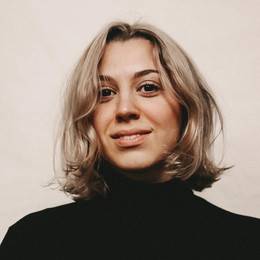 Porträt von Alicia Gentges Vizuete. Frau mit schulterlangen, blonden, gewellten Haaren lächelt in die Kamera.