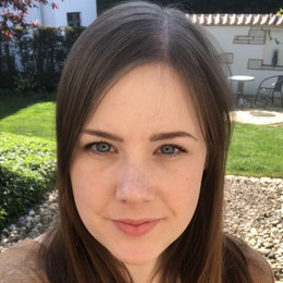 Porträt von Julia Wallmeier. Frau mit langen braunen Haaren lächelt in die Kamera.